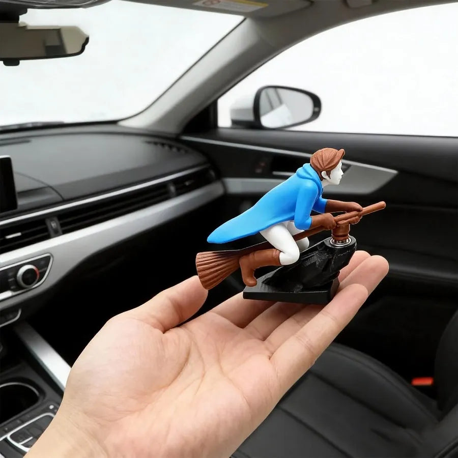A blue wizard dashboard drift ornament held in a human hand to show its actual size and scale inside a car.