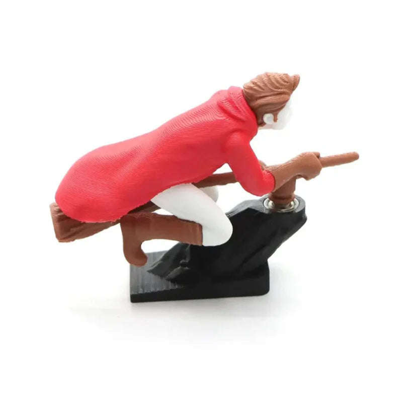 Side view of a red wizard riding a broomstick, designed as a drifting car dashboard ornament with a motion-bearing base.