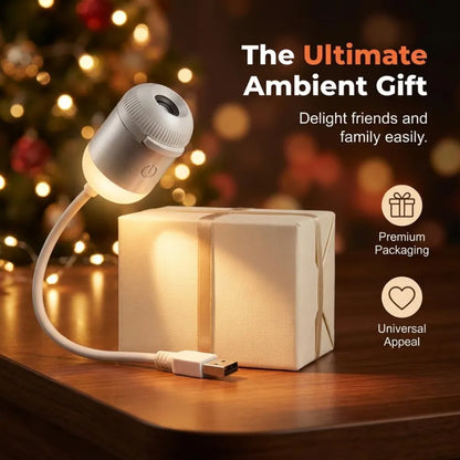 The mini starry night light projector illuminated next to a beautifully wrapped gift box under festive holiday lighting.