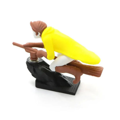 A 3D-printed yellow wizard riding a broomstick dashboard drift ornament on a rock-shaped base.